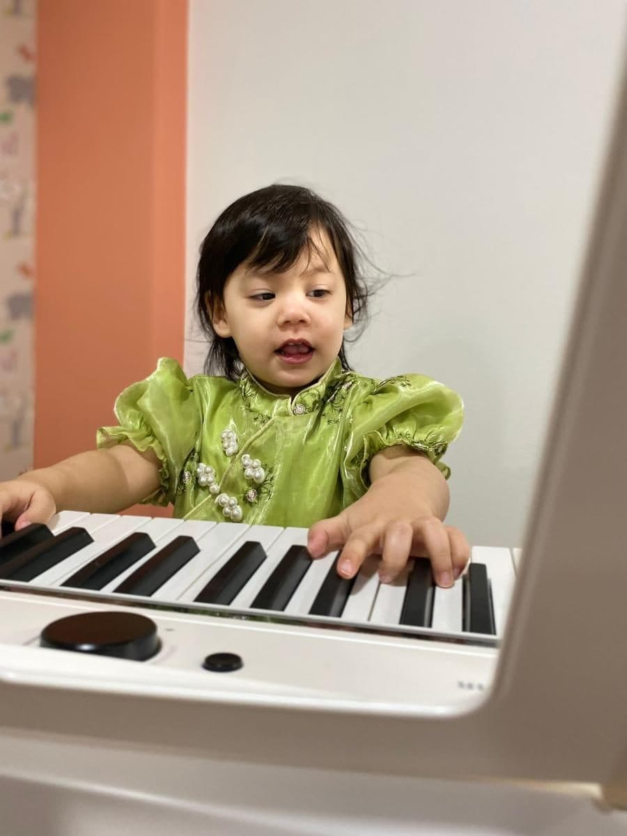 blossoming minds daycare child playing electronic keyboard instrument