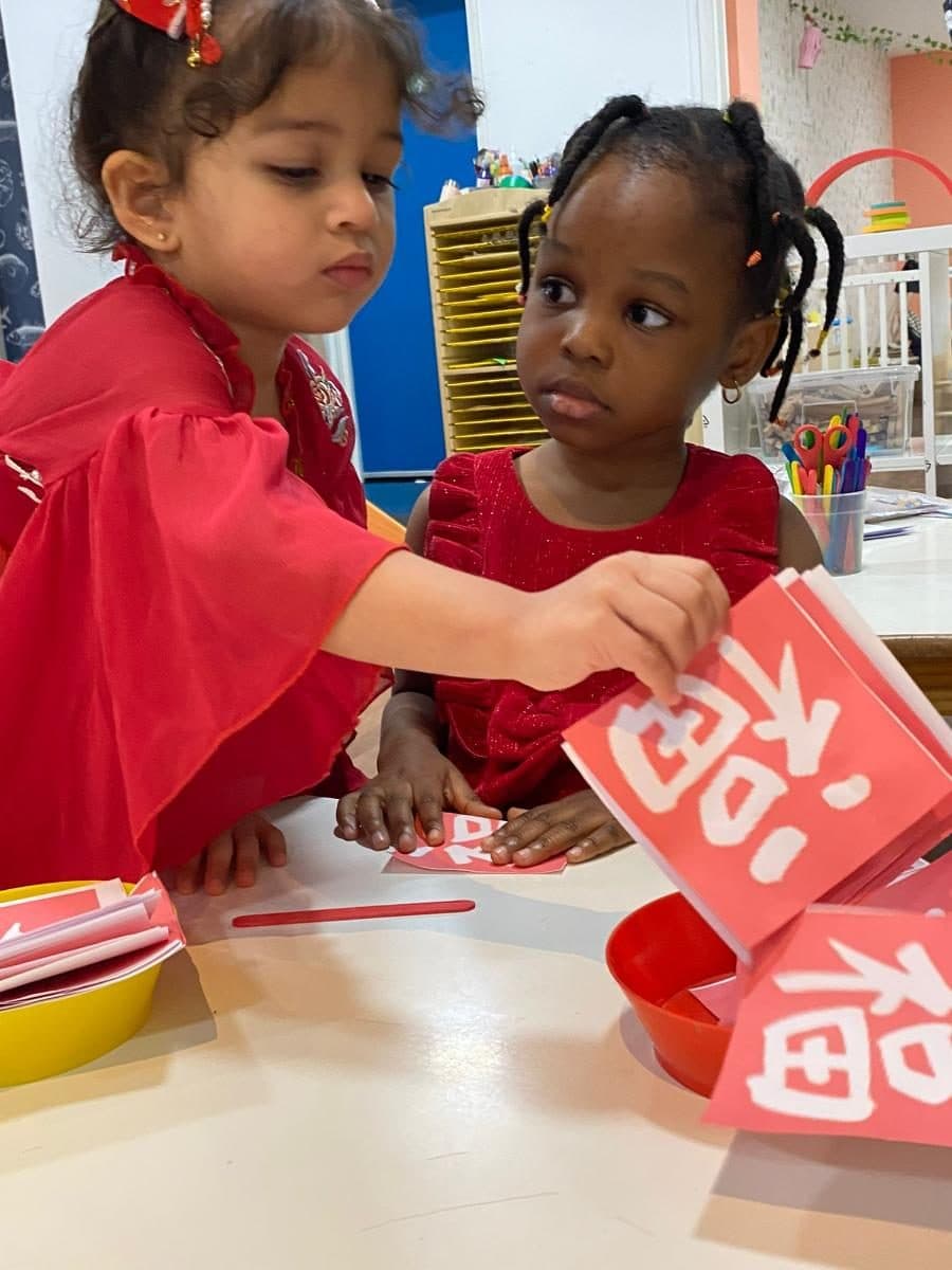blossoming minds daycare children crafting red paper projects together