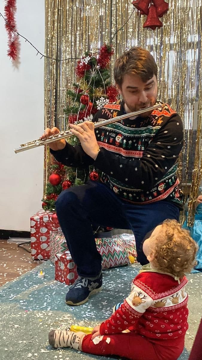 blossoming minds daycare practitioner playing flute for children