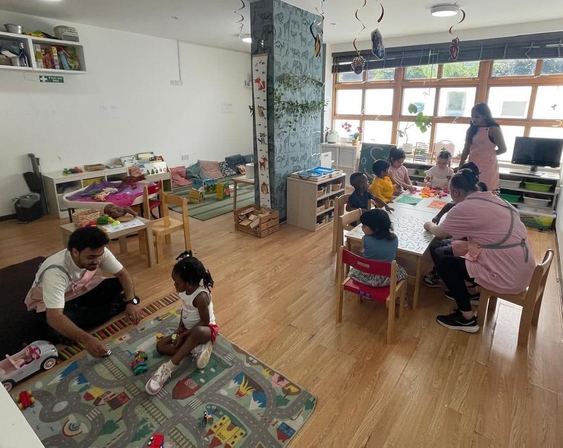 blossoming minds daycare practitioners supervise children playing indoors